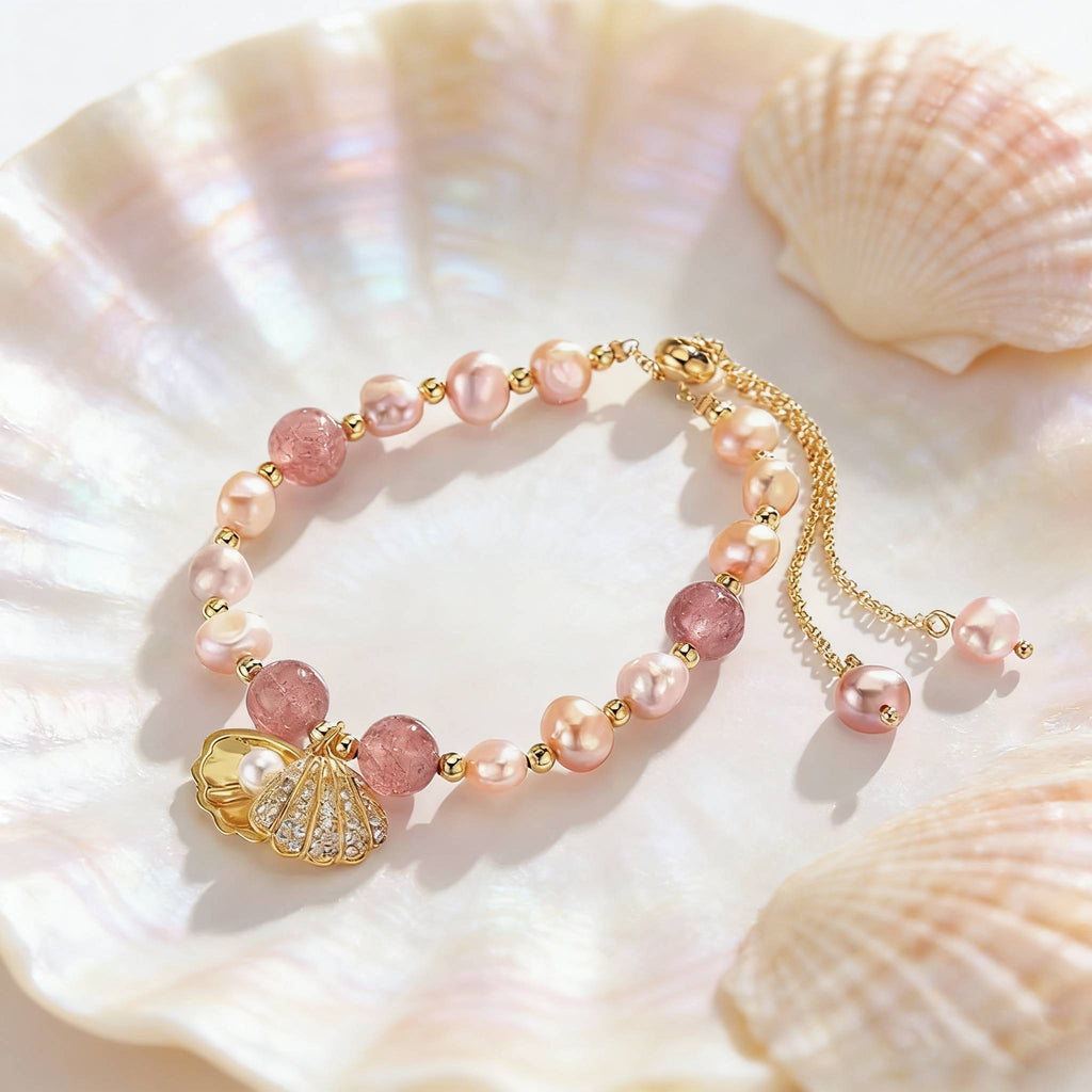 A delicate bracelet combining blush pearls and rosy beads, centered with a crystal-studded gold seashell pendant containing a small pearl.