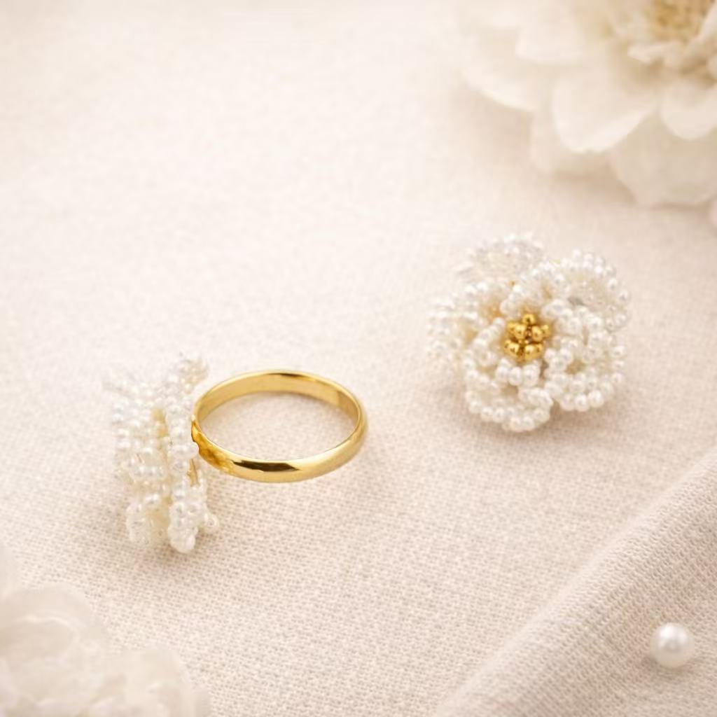 Gold ring with pearl accents on a soft beige background
