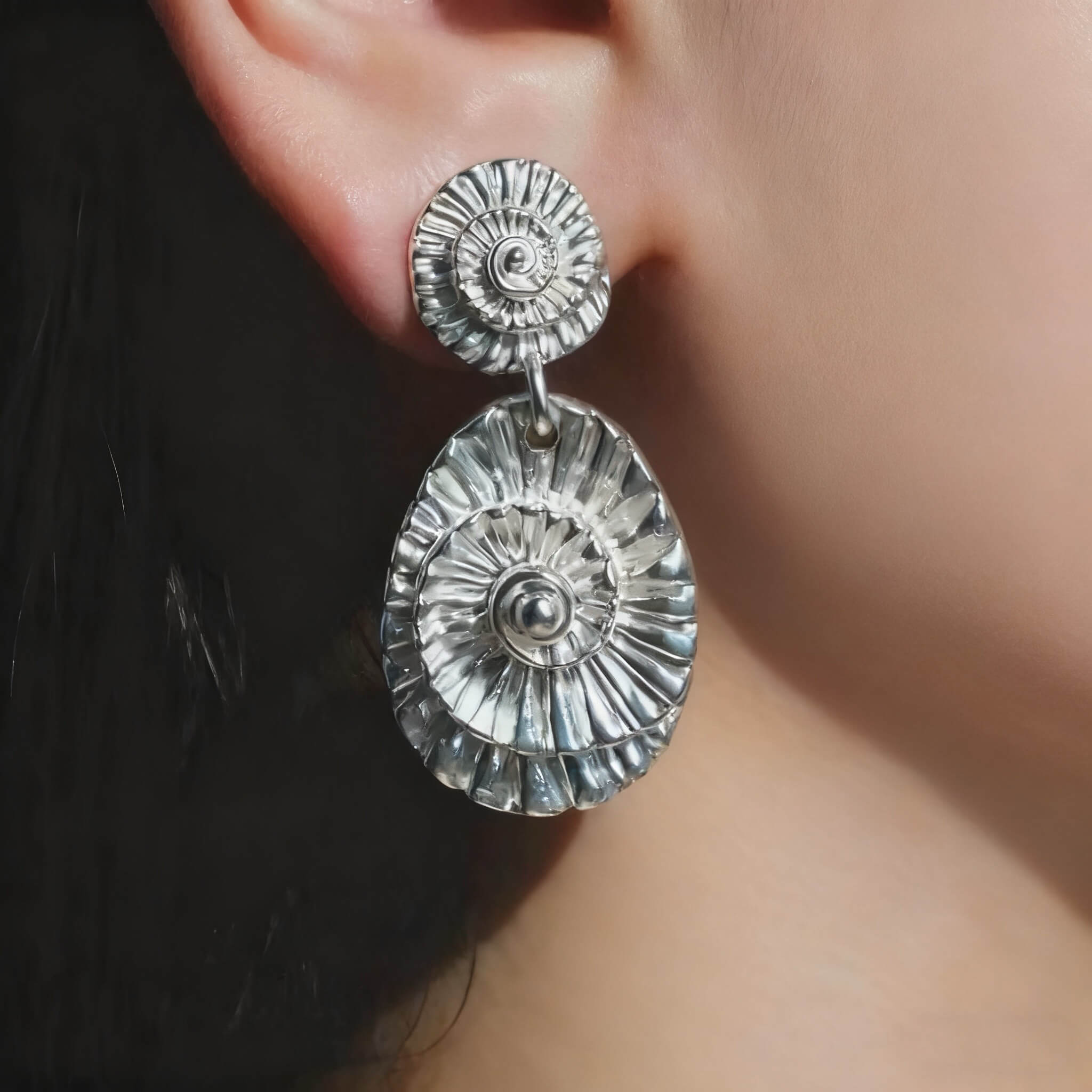 Boho-style silver seashell earrings with spiral and layered detailing.