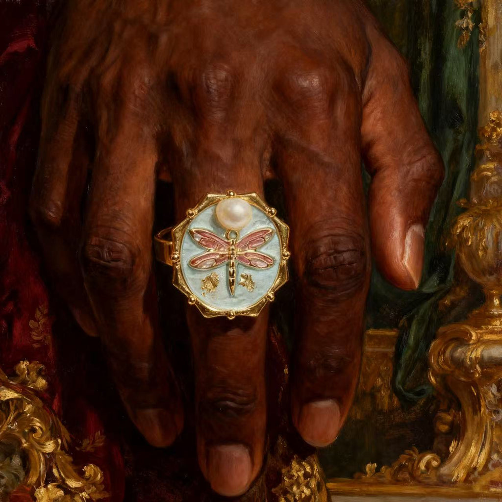 Vintage gold ring featuring a pink enamel dragonfly design with pearl accents and reflective golden background.