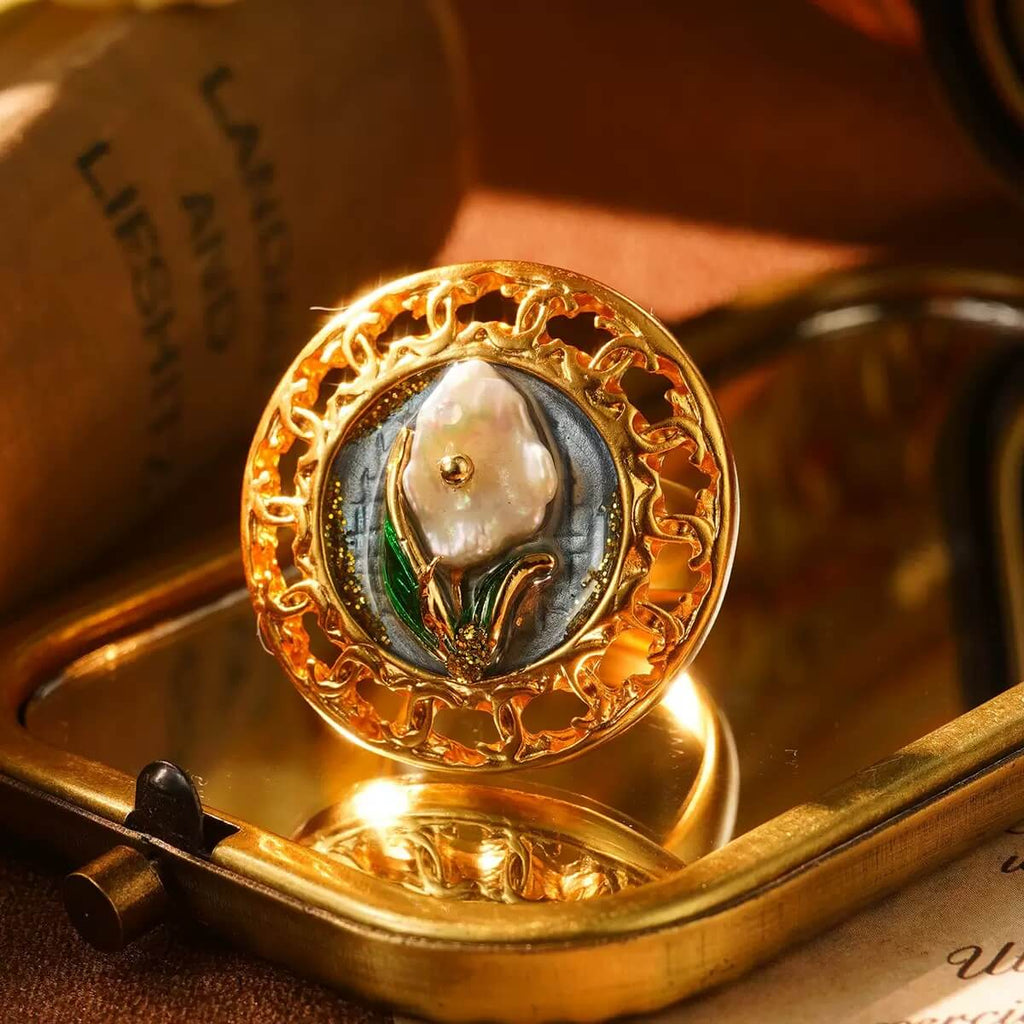 Handcrafted gold ring with a pearl centerpiece and decorative flower accents.