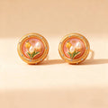 Gold tulip stud earrings with pearl flower buds and pink enamel background.