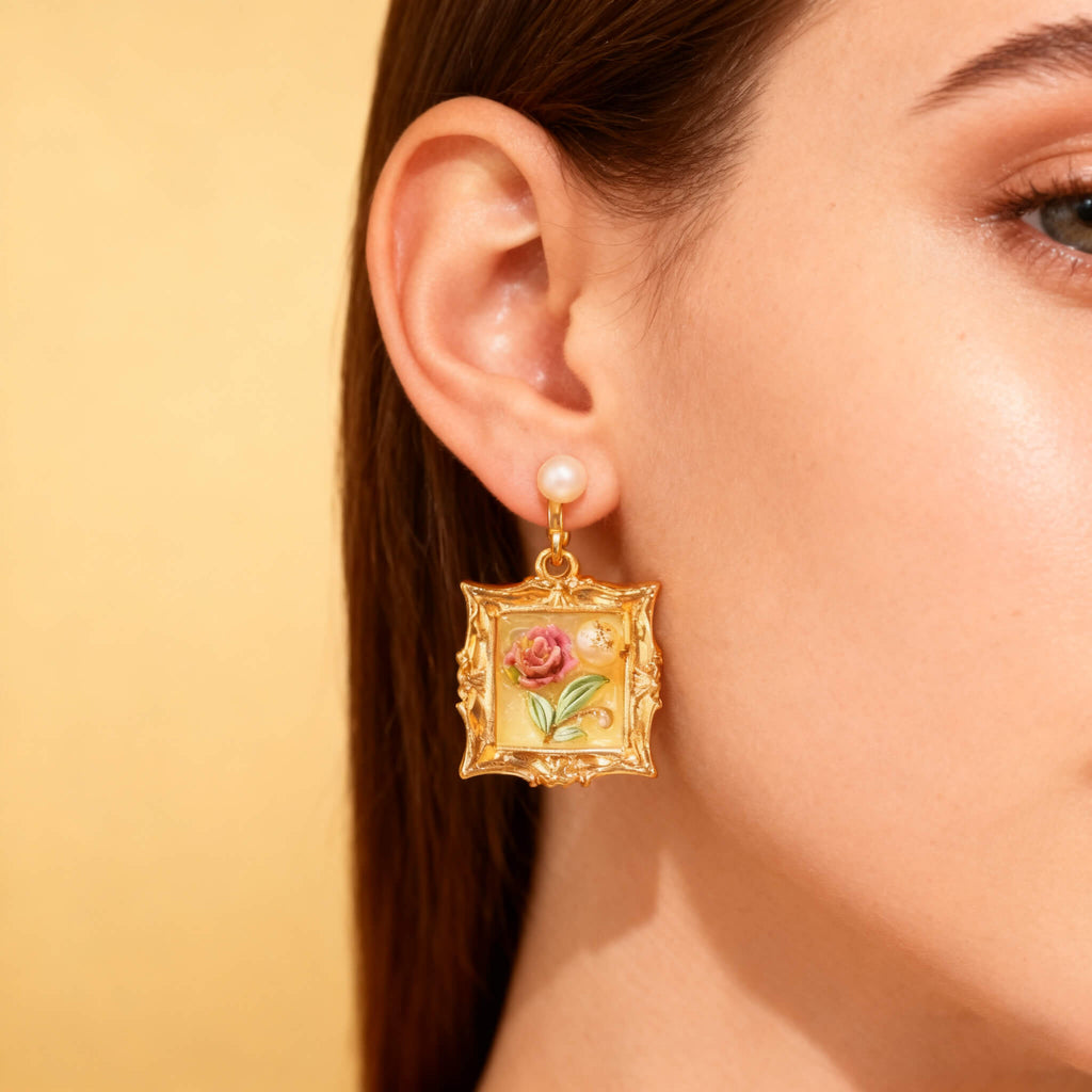 Elegant gold earrings with miniature framed rose painting, perfect for festive jewelry collections.