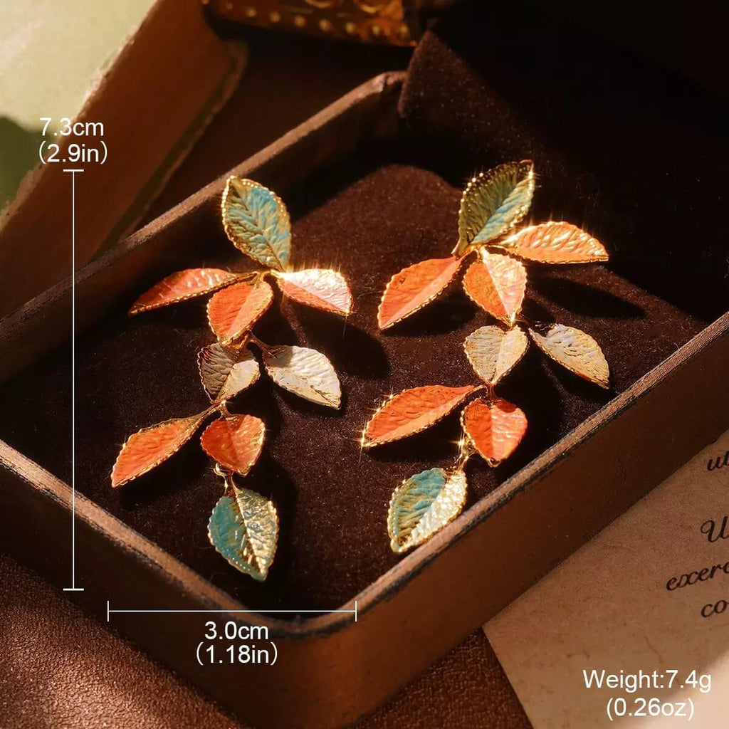 Vintage-inspired autumn leaf earrings featuring orange, teal, and gold enamel.