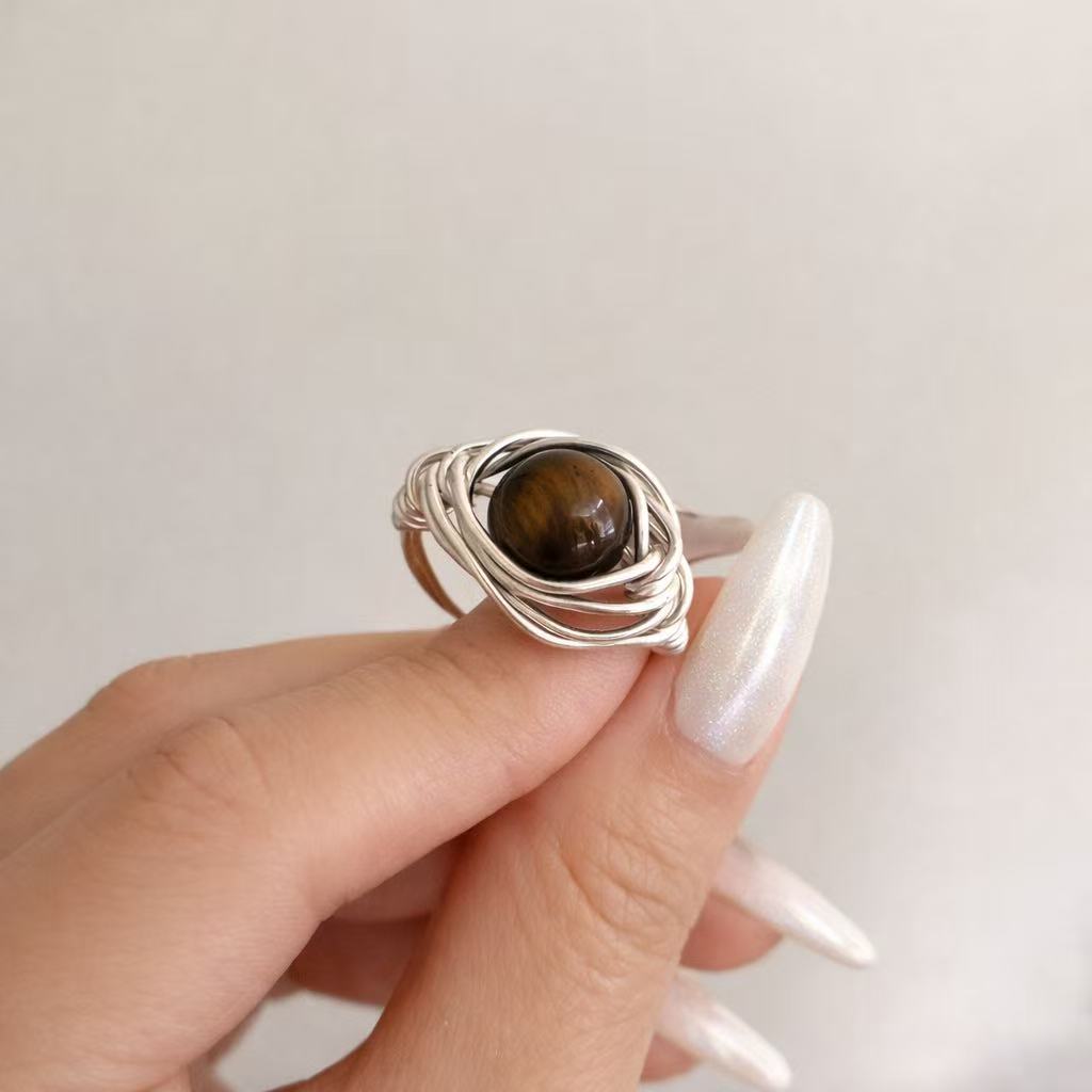 Minimalist handcrafted metal ring with layered wirework and a calm, sculptural form.