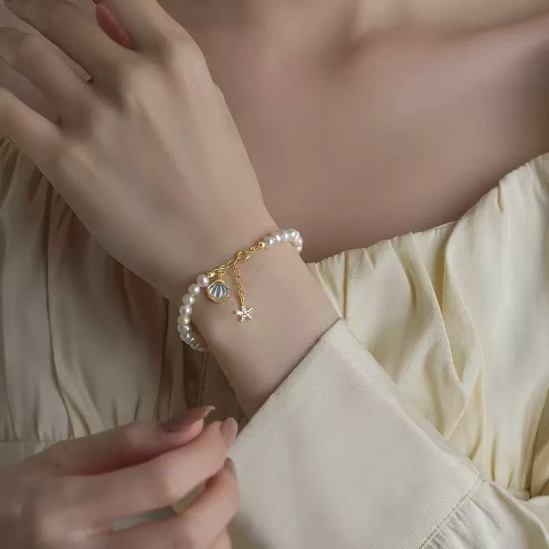 Pearl bracelet on a wrist with a neutral background