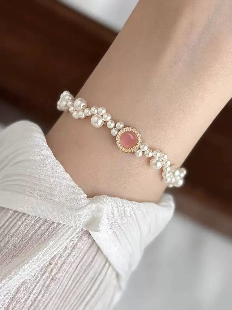 Handmade pearl bracelet featuring mixed-size pearls and a gold micro-pave setting that highlights a soft pink stone.