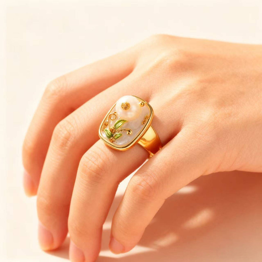 Handcrafted gold ring with a pearl centerpiece and decorative flower accents.