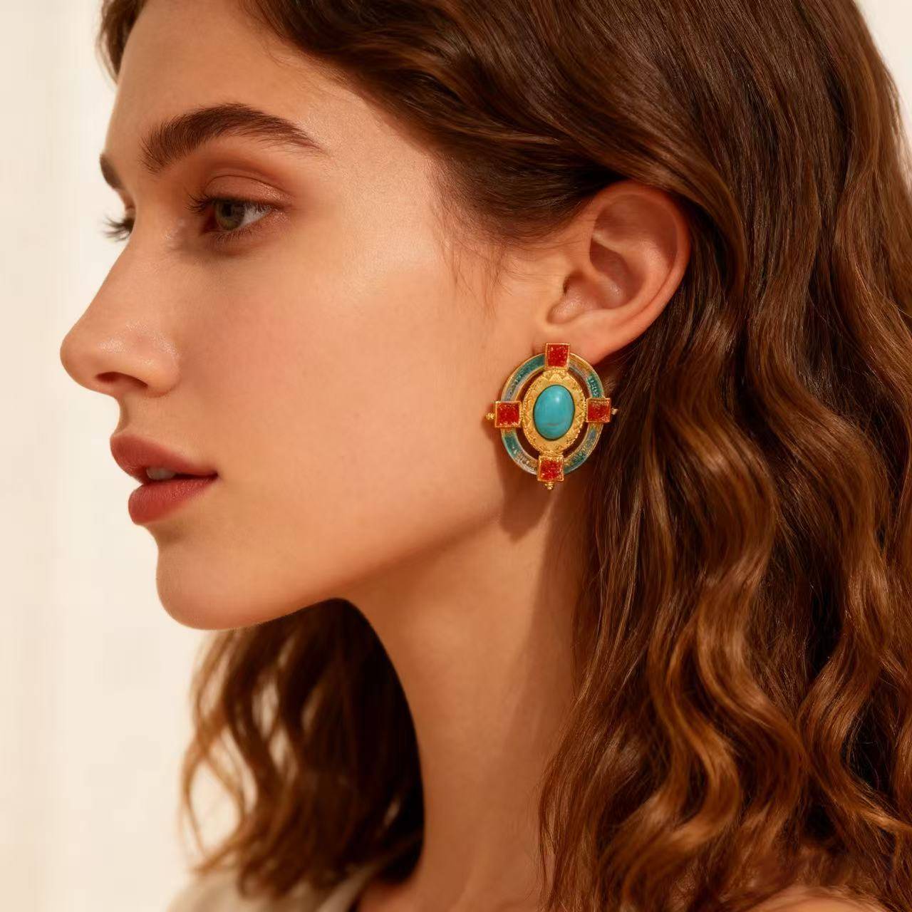 Gold-plated vintage earrings with turquoise stones, orange square gems, and blue enamel details displayed