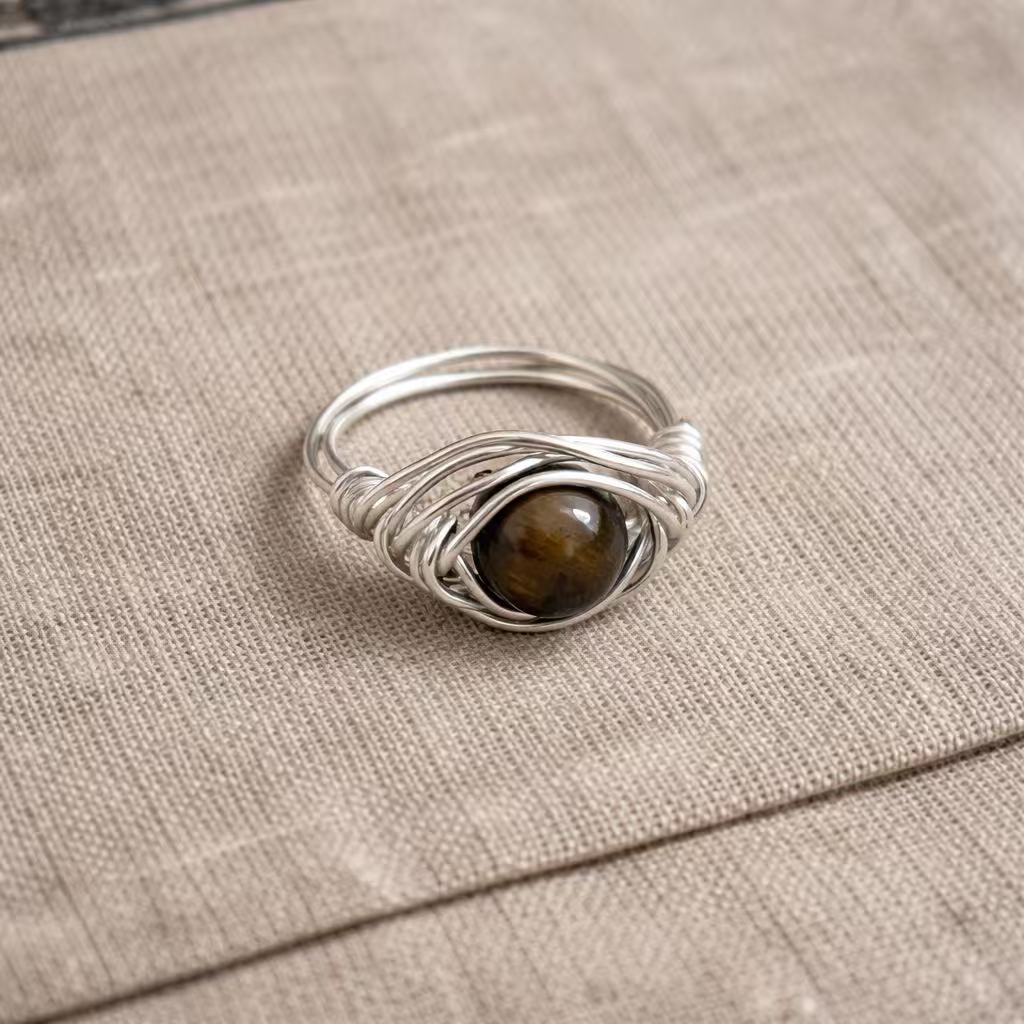 Handcrafted metal ring with wrapped wire design and natural stone centerpiece from the Arbor Aegis Bind collection.