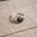 Handcrafted metal ring with wrapped wire design and natural stone centerpiece from the Arbor Aegis Bind collection.
