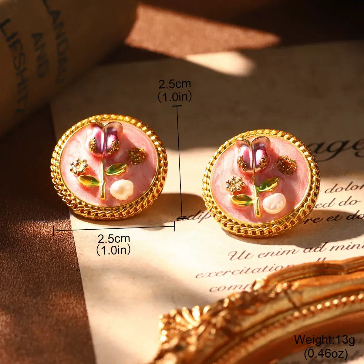 Handcrafted rose-motif earrings in pink enamel with gold accents and pearl-like bead