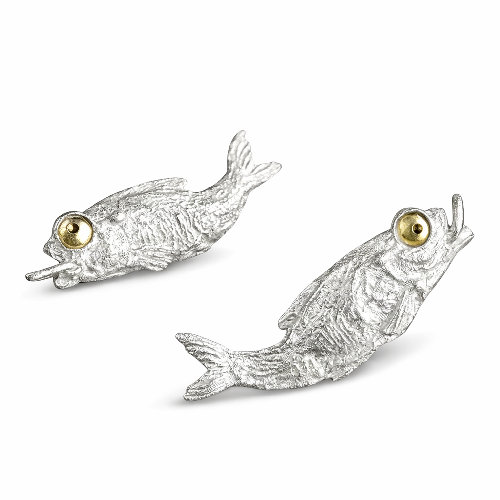 Pair of silver fish-shaped necklace with gold eyes on a white background