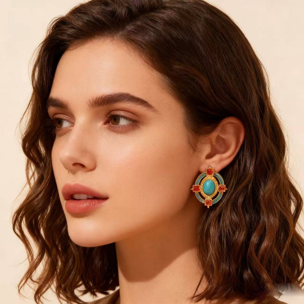 Gold-plated vintage earrings with turquoise stones, orange square gems, and blue enamel details displayed