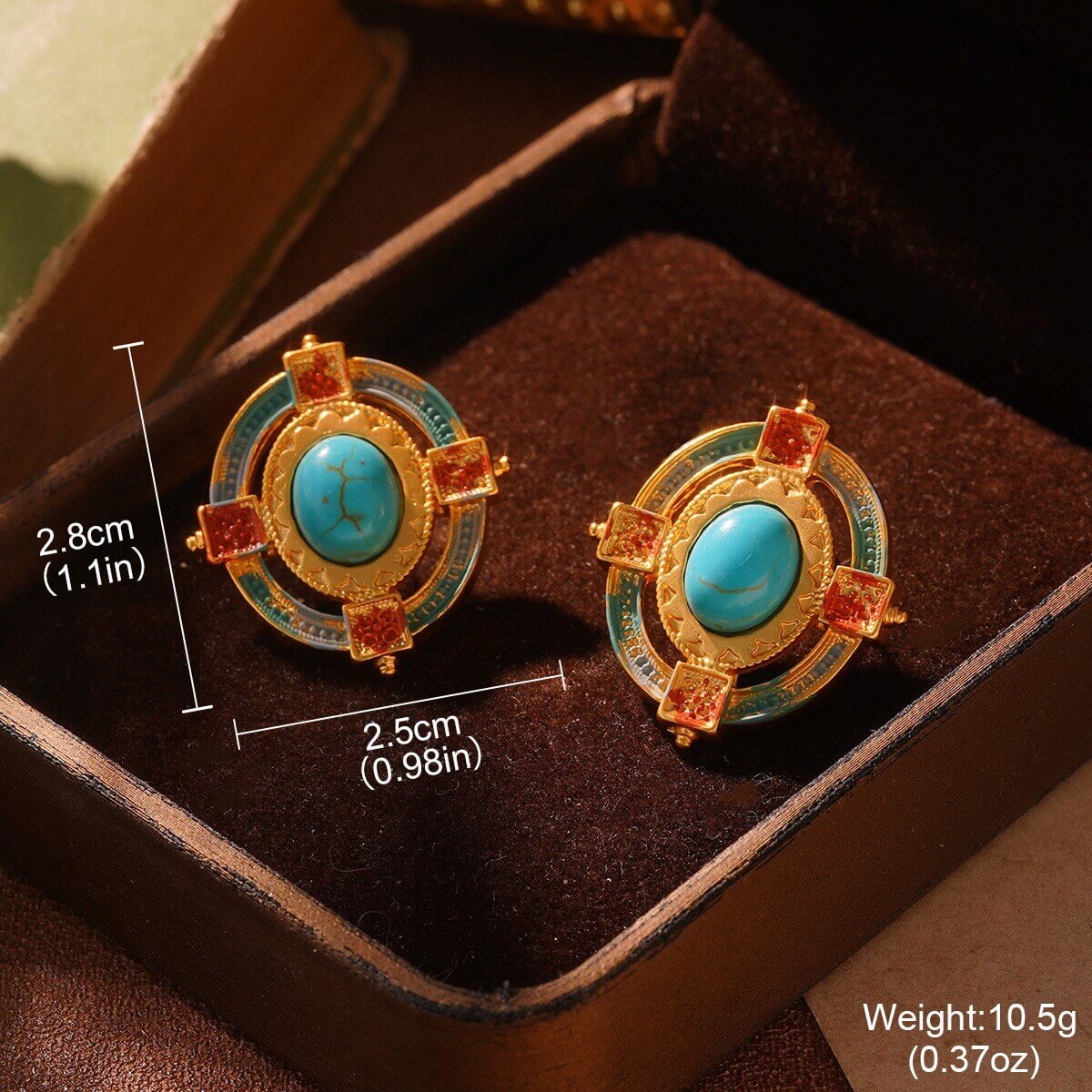 Gold effect earrings with turquoise stones on a brown velvet surface, with measurements and weight displayed.