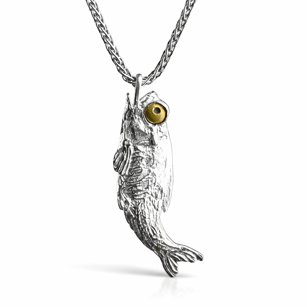 fish pendant with a gold eye on a chain against a white background