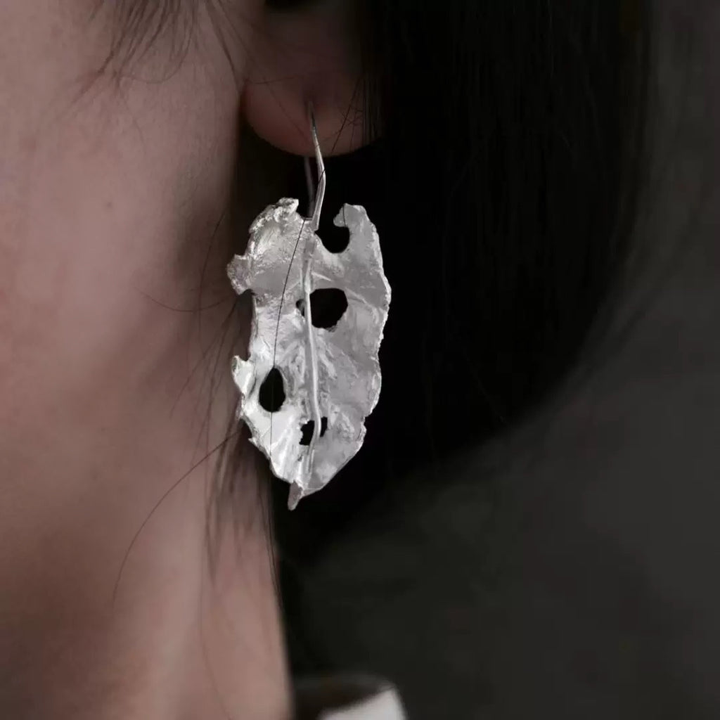 Handcrafted silver leaf-shaped earrings with organic textured design