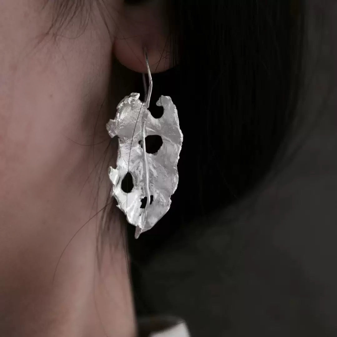Handcrafted silver leaf-shaped earrings with organic textured design