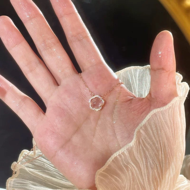 sparkling halo pendant necklace in rose gold resting on hand, chic and minimal jewelry