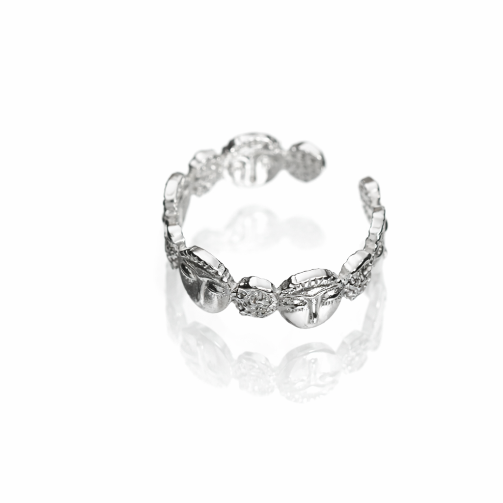 Silver ring with intricate design on a white background